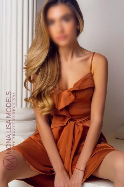 Maria seating down with long wavy hair